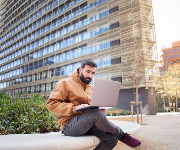 business-man-typing-on-laptop-computer-outdoors
